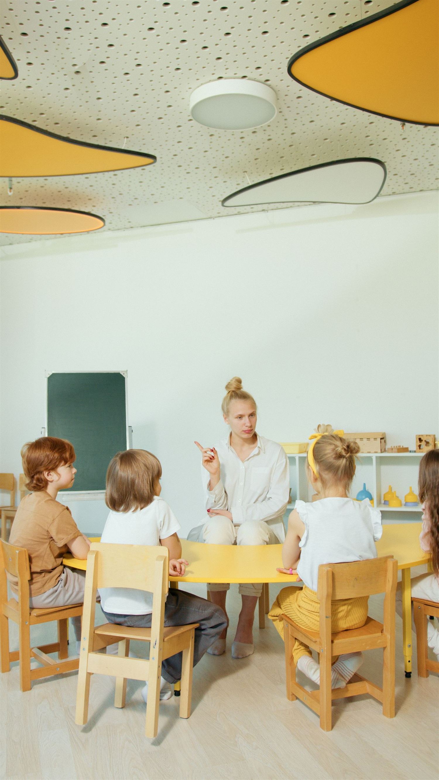 Classe de maternelle, une enseignante face à un groupe de jeunes enfants